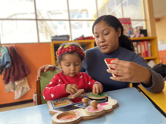 Profesor ejecutando ejercicios para estimular motricidad de niña