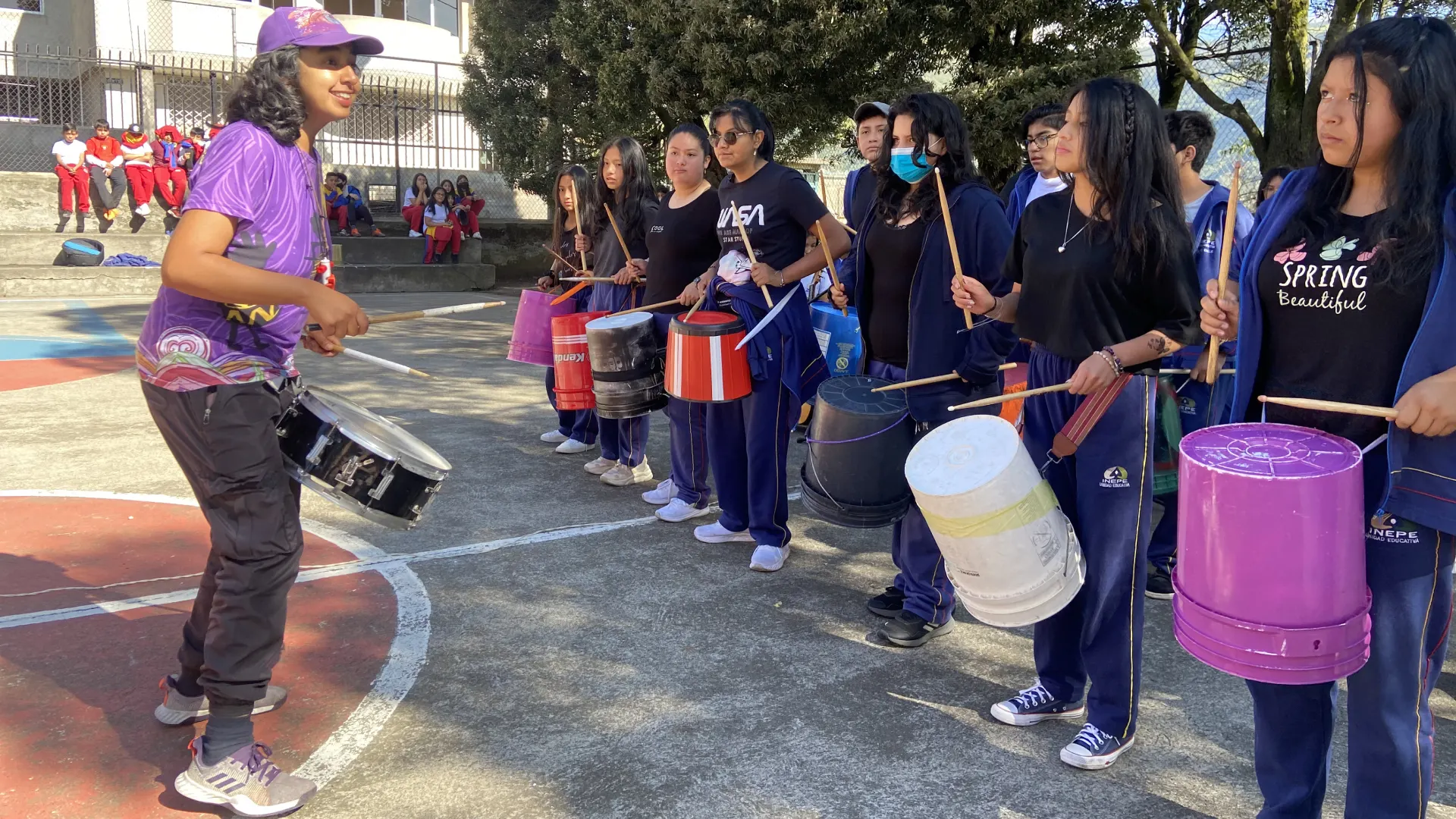 Estudiantes del Instituto INEPE experimentan con ritmos y percusión utilizando materiales reciclados en una actividad de aprendizaje musical.
