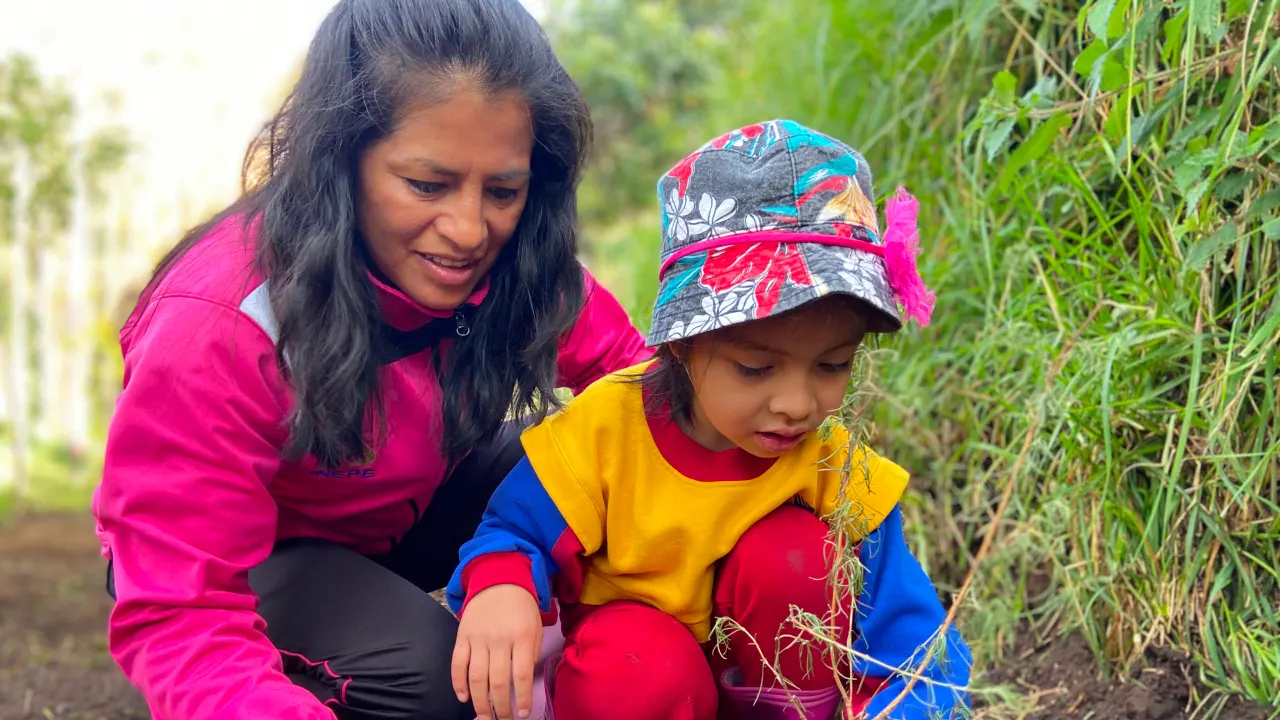 Profesor enseñando sobre el cuidado de la naturaleza a estudiante.